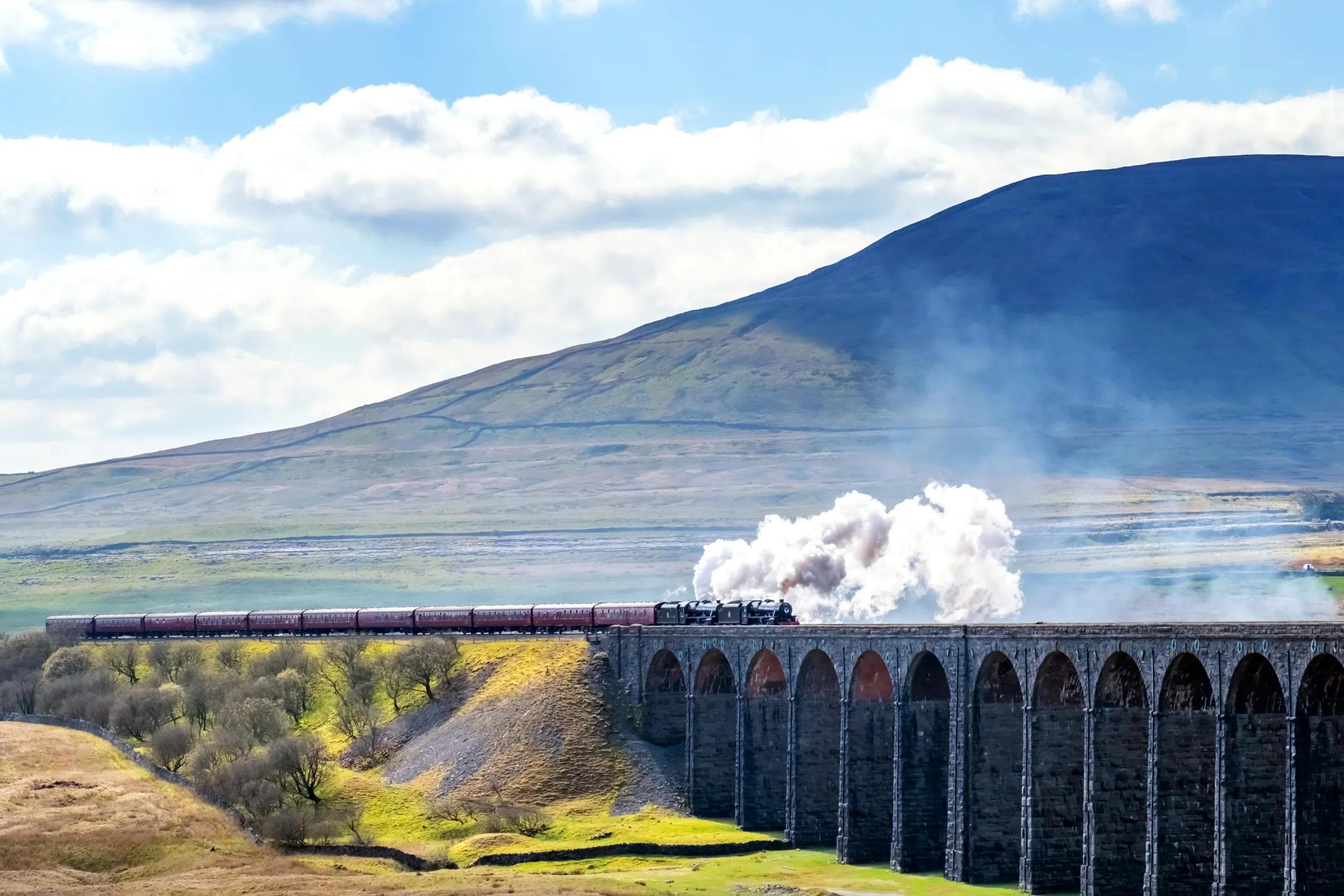 Locomotive steam trains crossing the Ribblehead Viaduct in the Yorkshire Dales, England, UK